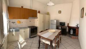 a kitchen with a table and a dining room at La casina dell'Annetta in Lido di Camaiore