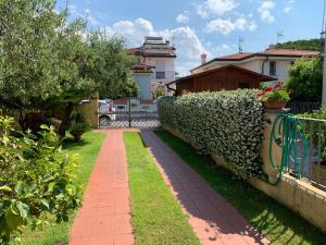 a walkway in a yard next to a fence at La casina dell'Annetta in Lido di Camaiore
