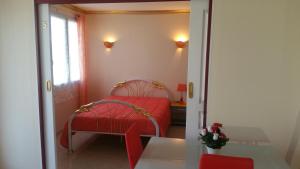 a small bedroom with a red bed and a window at l'ESCALE à 50 m de la gare in Viry-Châtillon