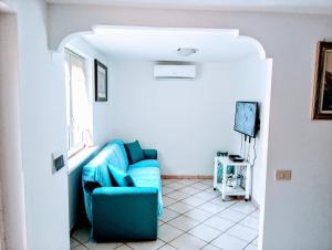 a living room with a blue couch and a window at Villino Via Sabaudia 39 in San Felice Circeo