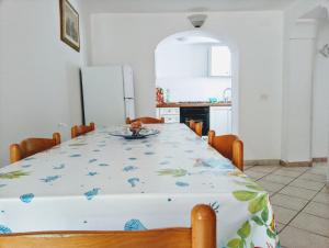 uma sala de jantar com uma mesa e um frigorífico em Villino Via Sabaudia 39 em San Felice Circeo