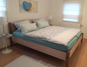 ein Bett in einem Schlafzimmer mit blauem Herz an der Wand in der Unterkunft Ferienwohnung Tischneck in Schramberg