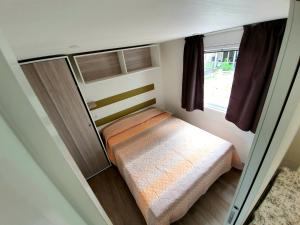 Habitación pequeña con cama y ventana en Camping Parisi, en Baveno