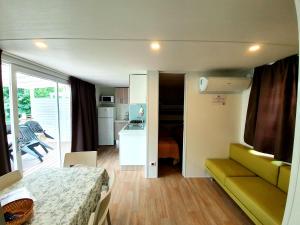 Habitación con cama y cocina con balcón. en Camping Parisi en Baveno