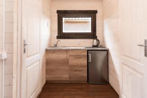 ein kleines Badezimmer mit Waschbecken und Fenster in der Unterkunft Vasarnamiai 2 in Šventoji