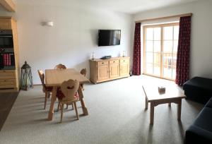 a living room with a table and chairs and a tv at Ferienwohnung Hochstein in Haus im Ennstal