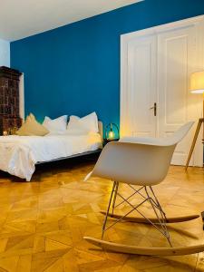 a blue bedroom with a bed and a chair at Crops City Stay in Trieste