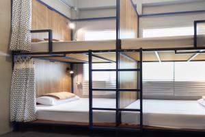 a bunk bed in a room with a window at Arawana Hostel Silom in Bangkok