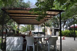 a patio with a table and chairs under a wooden pergola at Kemer Park Otel in Kemer