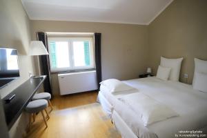 una camera da letto con un grande letto bianco e una finestra di Quarto Piano Rooms a Genova