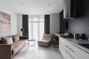 a kitchen and living room with a couch and a table at Beskyd Suites in Bukovel
