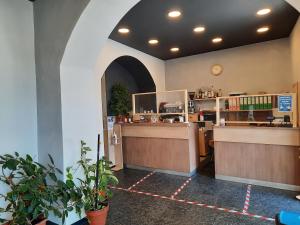 Hotel Le Tre Stazioni في جينوا: مطعم يوجد به كاونتر وبعض النباتات
