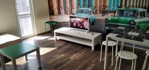 a living room with a tv and an old car on display at Draga Apartment in Nesebar