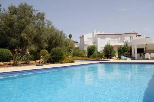 a large blue swimming pool in front of a house at Casas da Vila in Luz