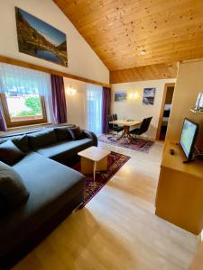 uma sala de estar com um sofá e uma mesa em Appartement Pension St. Sebastian em Pettneu am Arlberg