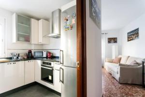 eine Küche mit einem Kühlschrank und einem Sofa in einem Zimmer in der Unterkunft Anna Triana Boutique Apartament in Sevilla
