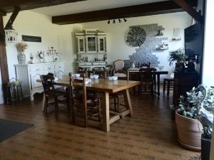 a kitchen and dining room with a wooden table and chairs at Les Mesanges in Combrand