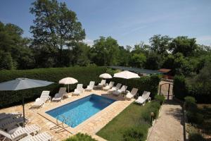 a swimming pool with lounge chairs and umbrellas at House Antonac in Novigrad Istria
