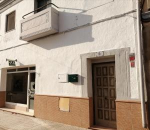 un bâtiment blanc avec une porte dans une rue dans l'établissement Can Ventura, à Deltebre