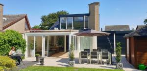 Casa con patio con sombrilla en Lake house 21 relax accommodation iR Sauna en Warmond