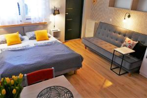sypialnia z dużym łóżkiem i kanapą w obiekcie Apartamenty i Mieszkania Wakacyjne w Chałupach