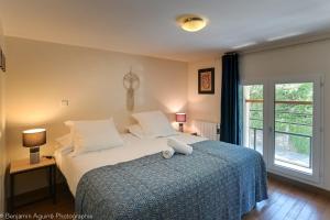 1 dormitorio con 1 cama con manta azul y ventana en L'Angle du Lac - Duplex feet in the water of Lake Annecy, en Duingt