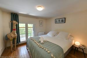 Un dormitorio con una cama con una jirafa disecada. en L'Angle du Lac - Duplex feet in the water of Lake Annecy, en Duingt
