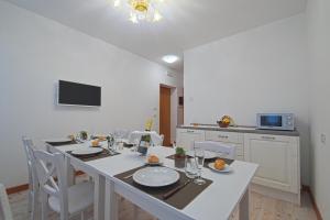 a dining room with a white table and chairs at Palazzetto Canossa in Venice