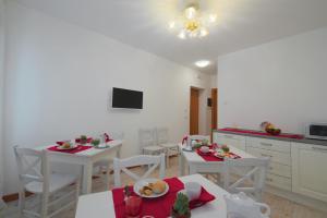 a kitchen with white tables and white chairs with food on them at Palazzetto Canossa in Venice