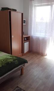 um quarto com uma cama e uma grande janela em Pokoje Gościnne u Teresy em Mrzeżyno
