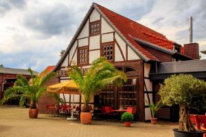 un bâtiment avec un restaurant avec des palmiers devant lui dans l'établissement Landhaus Akazienhof, à Nordstemmen