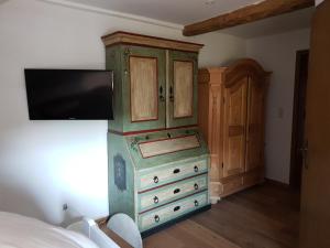 a bedroom with a dresser with a tv on top of it at Landhaus Akazienhof in Nordstemmen