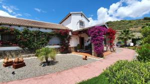 una casa con flores a un lado. en Bed & Breakfast | Guest House Casa Don Carlos en Alhaurín el Grande