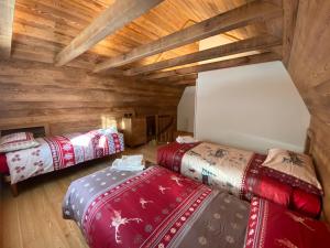 three beds in a room with wooden walls at B&B Torri di Veglia in San Domenico