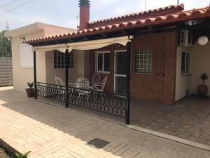 a porch of a house with a fence at cozy cottage in the suburbs in Kalamata