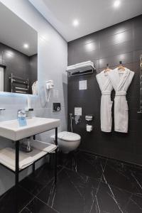 a bathroom with a white toilet and a sink at Beskyd Suites in Bukovel