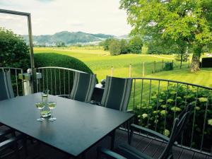 una mesa con 2 copas de vino en el balcón en Das Ferienhaus, en Attersee am Attersee