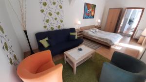 a living room with a blue couch and two chairs at Willa Pasat in Władysławowo