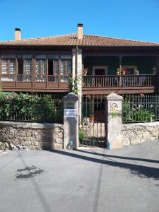 a large house with a balcony and a fence at Casa de Aldea Florentina in Arenas de Cabrales