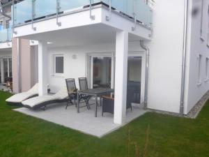 une terrasse avec une table et des chaises. dans l'établissement Ferienwohnung am Yachthafen, à Kressbronn am Bodensee