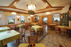 uma sala de jantar com mesas, cadeiras e lustres em Landhotel Gasthof Zwota em Klingenthal