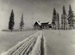 una casa en la nieve con huellas en la nieve en Chata Orlí vrch en Zlaté Hory