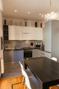 a kitchen with a black table and white cabinets at Luxury Penthouse with Sea View - City Center in Pescara