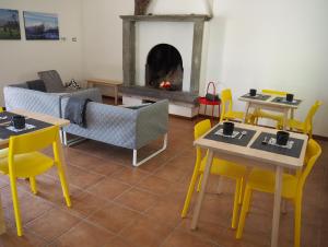a living room with tables and chairs and a fireplace at Open Cascina in Colico