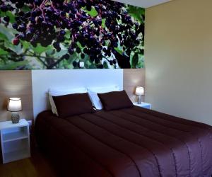 1 dormitorio con 1 cama grande y una pintura en la pared en Quinta do Lameiro en Tarouca