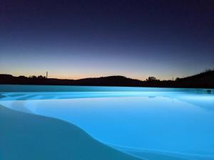 a blue lake at night with mountains in the background at Gite de Fleurie - Tursac in Tursac