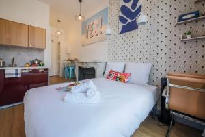 a large white bed in a room with a kitchen at Apartments WS Haussmann - La Fayette in Paris