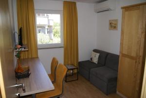 un soggiorno con divano e finestra di Rooms Magdalena Krk a Krk