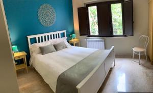 a bedroom with a large white bed with blue walls at Corte dei medici - Palace in Catania