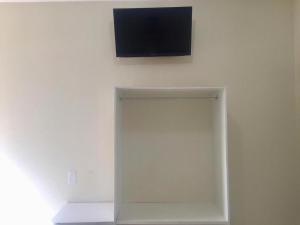 a flat screen tv on a wall with a white wall at Pousada Central in Feira de Santana